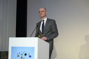 Mannin Anzug an Pult - Dr. Holm Graeßner hält Dankesrede bei Black Pearl Awards