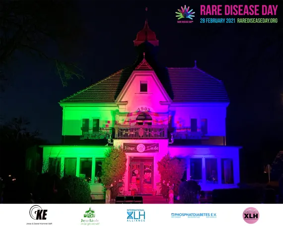 Haus angestrahlt zum rare Disease Day. Es ist dunkel. 