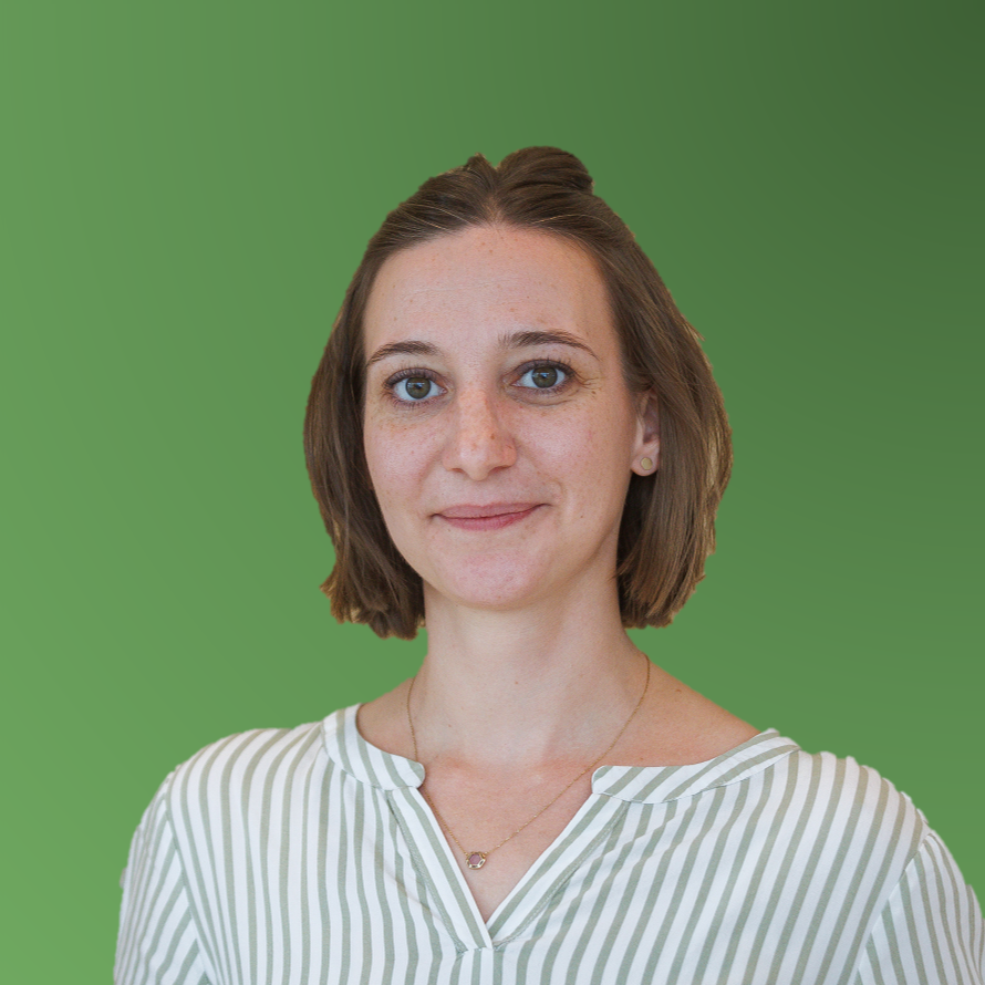 Frau mit schulterlangem braunem Haar, trägt gestreifte Bluse und feine Halskette, vor grünem Hintergrund