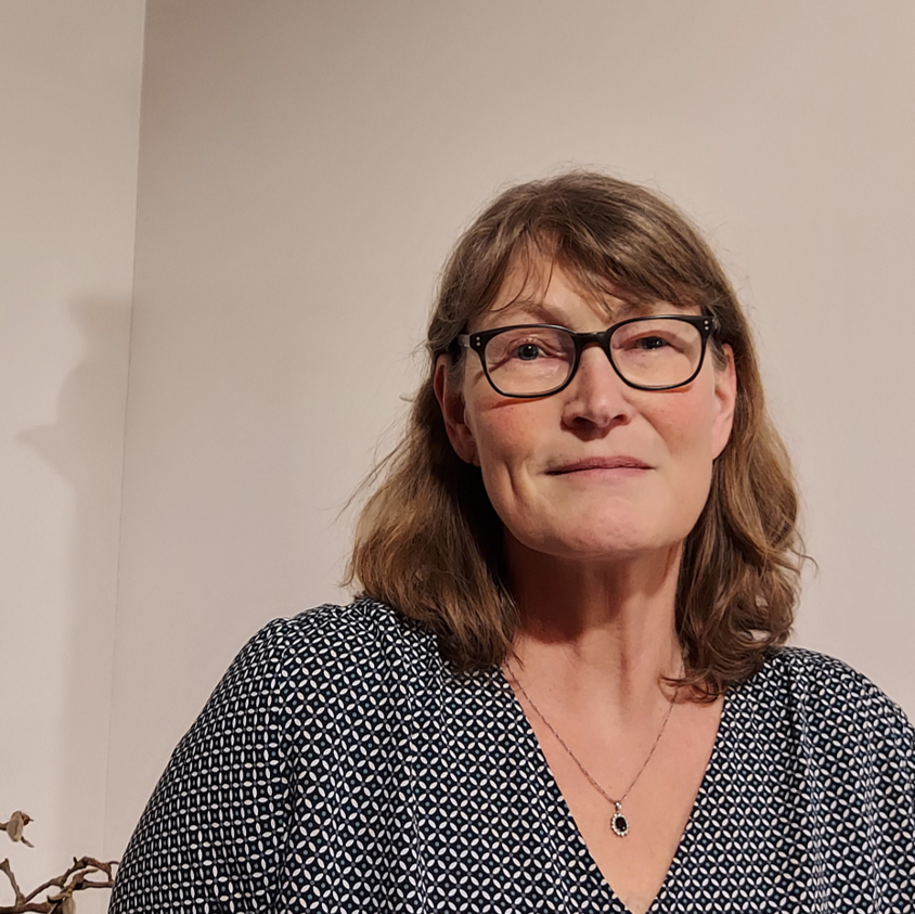 Marion Wilkens, 1. Vorsitzende des alpha1 e.V., eine Frau mit schulterlangen, dunkelblonden Haaren, einer schwarz gerahmten Brille und einer Bluse  