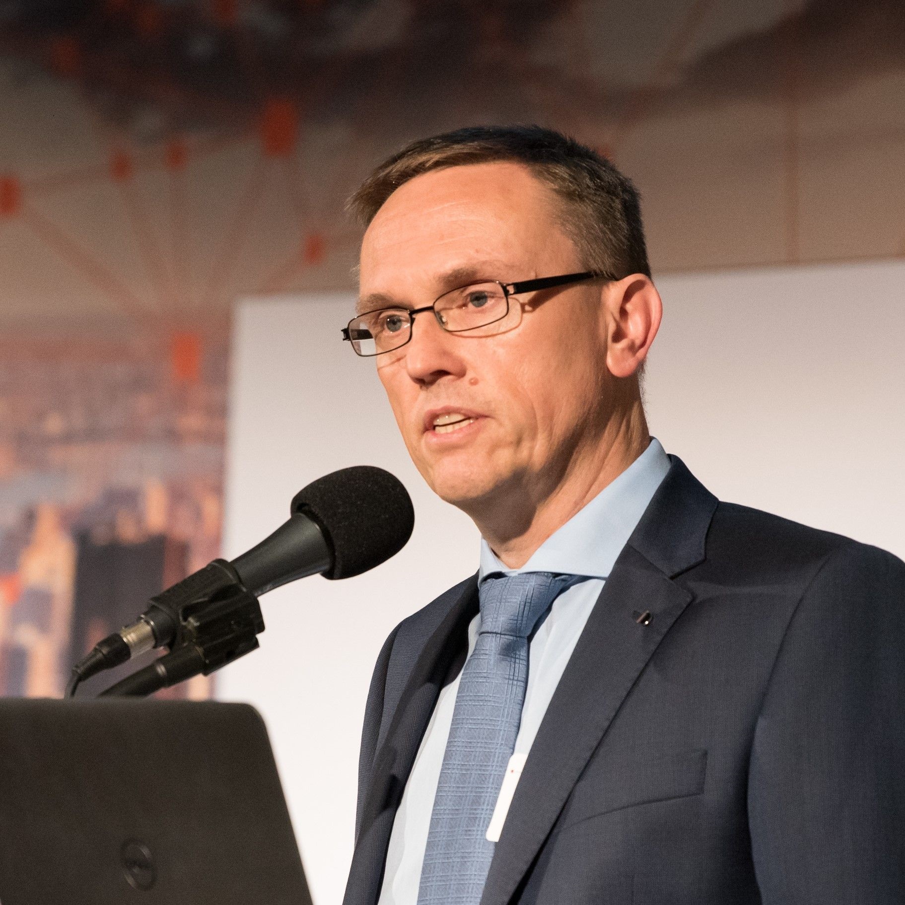 Mann mit kurzen brauchen Haaren, rechteckiger Brille und Anzug mit Krawatte Mann mit kurzen brauchen Haaren, rechteckiger Brille und Anzug mit Krawatte