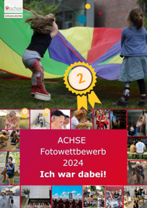 Zwei Kinder spielen mit einem bunten Fallschirm im Freien, eines trägt rote Stiefel und graue Shorts, das andere ein blaues Kleid.