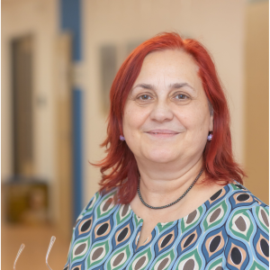 Uta Kurzwelly Frau mit roten Haaren trägt ein gemustertes Oberteil