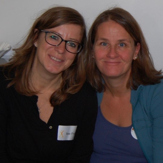 Zwei Frauen mit langen Haaren , die Kopf an Kopf in die Kamera schaue